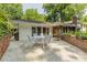 Outdoor patio with a dining table and chairs, brick retaining wall, and water feature at 6825 Castleton Dr, Atlanta, GA 30328