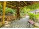 Secluded backyard retreat with brick patio and a wooden swing under a vine-covered trellis at 6825 Castleton Dr, Atlanta, GA 30328