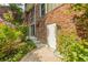 Brick home exterior featuring lush landscaping, patio access and white entry door at 6825 Castleton Dr, Atlanta, GA 30328