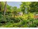 Expansive backyard with tiered gardens and mature trees, creating a private oasis at 6825 Castleton Dr, Atlanta, GA 30328