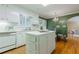 Bright eat-in kitchen features hardwood floors, white cabinetry, and a center island at 6825 Castleton Dr, Atlanta, GA 30328