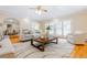 Bright and airy living room with hardwood floors, neutral decor, and access to the dining area at 6825 Castleton Dr, Atlanta, GA 30328