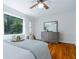 Bright primary bedroom with hardwood floors, a ceiling fan, and scenic views from the large window at 6825 Castleton Dr, Atlanta, GA 30328