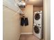 A conveniently stacked washer and dryer unit with storage shelves and hanging rack for clothes at 711 Cosmopolitan Ne Dr # 338, Atlanta, GA 30324