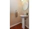 This powder room features a pedestal sink, hardwood floors, and neutral color scheme at 711 Cosmopolitan Ne Dr # 338, Atlanta, GA 30324