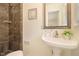 Bathroom with patterned tile shower and pedestal sink with a decorative mirror and neutral paint color at 2070 Brannen Se Rd, Atlanta, GA 30316