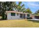 A single-story home with a well-maintained lawn, showcasing its crisp white exterior and turquoise door and shutter trim at 2070 Brannen Se Rd, Atlanta, GA 30316