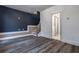 Large empty room with hardwood style floors, blue accent wall, and tiled bathroom at 2323 Mason Dr # D21, Atlanta, GA 30316
