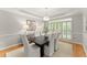 Formal dining room with wainscoting, tray ceiling, and a large window with shutters, offering natural light at 3049 Brightwood Se Ln, Marietta, GA 30067
