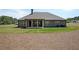 Rear exterior showcasing a covered patio, neat landscaping, and well-maintained lawn at 485 Discovery Lake Dr, Fayetteville, GA 30215