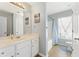 Bright bathroom featuring double sinks, white cabinets, and a shower/tub combo at 5415 Fieldfreen Dr, Cumming, GA 30028