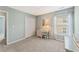Cozy bedroom featuring a desk area, plush carpet, and bright natural light from the large window at 5415 Fieldfreen Dr, Cumming, GA 30028