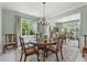 Light-filled dining room featuring a large window, elegant chandelier, and a view into the adjacent office at 5415 Fieldfreen Dr, Cumming, GA 30028