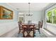 Elegant dining room with a large round table, chandelier, wainscoting, and a view of the adjoining living spaces at 5415 Fieldfreen Dr, Cumming, GA 30028