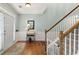 Inviting foyer featuring hardwood floors, staircase with white railings, and classic wainscoting, leading to the home's interior at 5415 Fieldfreen Dr, Cumming, GA 30028