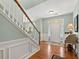 Bright foyer with hardwood floors, staircase, wainscoting, and a view of the front door, creating a welcoming entrance at 5415 Fieldfreen Dr, Cumming, GA 30028