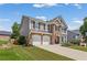 Well-maintained home showcasing a stone and vinyl facade, two-car garage, and landscaped yard in a suburban setting at 5415 Fieldfreen Dr, Cumming, GA 30028
