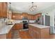 A well-appointed kitchen with wood cabinets, modern appliances, an island, and an elegant lighting fixture at 5415 Fieldfreen Dr, Cumming, GA 30028