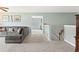 Comfortable upstairs living room featuring a large sectional couch and access to stairs at 5415 Fieldfreen Dr, Cumming, GA 30028