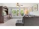 This living room features lots of seating, a ceiling fan, and a decorative bookcase at 5415 Fieldfreen Dr, Cumming, GA 30028