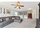 Upstairs living room featuring a large sectional couch, ceiling fan, and easy access to other rooms at 5415 Fieldfreen Dr, Cumming, GA 30028