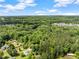 An aerial view shows the property nestled in lush greenery under a partly cloudy sky at 5902 Wills Orchard Rd, Cumming, GA 30040