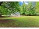 Spacious backyard with new brick paver patio, lawn, and mature trees offering a serene outdoor experience at 5902 Wills Orchard Rd, Cumming, GA 30040