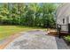 Large backyard featuring a brick paver patio, a wood deck, lush lawn, and a chain-link fence, perfect for pets at 5902 Wills Orchard Rd, Cumming, GA 30040