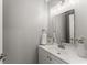 Stylish half bathroom features a modern vanity with a decorative mirror and brushed nickel hardware at 5902 Wills Orchard Rd, Cumming, GA 30040