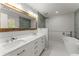 Modern bathroom featuring a dual sink vanity, soaking tub, and separate shower at 5902 Wills Orchard Rd, Cumming, GA 30040
