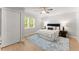 Cozy bedroom with hardwood floors, a ceiling fan, and a large window for natural light at 5902 Wills Orchard Rd, Cumming, GA 30040