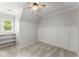 Light-filled bedroom featuring a ceiling fan, custom shelving, and a bright window at 5902 Wills Orchard Rd, Cumming, GA 30040