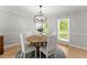 Well-lit dining room with a round table, modern chandelier, and large window at 5902 Wills Orchard Rd, Cumming, GA 30040