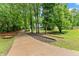 Long driveway leading to a charming one-story home surrounded by beautiful trees and lush greenery at 5902 Wills Orchard Rd, Cumming, GA 30040