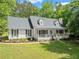 Charming one-story home featuring a welcoming front porch, a well-manicured lawn and beautiful surrounding trees at 5902 Wills Orchard Rd, Cumming, GA 30040