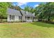 Charming one-story home featuring a welcoming front porch, a well-manicured lawn and beautiful surrounding trees at 5902 Wills Orchard Rd, Cumming, GA 30040