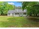 Charming one-story home featuring a welcoming front porch, a well-manicured lawn and beautiful surrounding trees at 5902 Wills Orchard Rd, Cumming, GA 30040