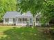 Charming one-story home with a welcoming front porch, a well-manicured lawn and beautiful surrounding trees at 5902 Wills Orchard Rd, Cumming, GA 30040