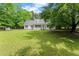 Expansive front yard featuring a charming one-story home with a welcoming front porch and beautiful surrounding trees at 5902 Wills Orchard Rd, Cumming, GA 30040