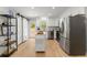 Modern kitchen features stainless steel appliances, white cabinets, and a central island with wood countertop at 5902 Wills Orchard Rd, Cumming, GA 30040