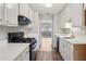 Galley kitchen with white cabinets, quartz countertops and black appliances at 6806 Glenridge Dr # E, Atlanta, GA 30328