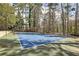 Well-maintained blue and green community tennis court surrounded by trees at 6806 Glenridge Dr # E, Atlanta, GA 30328