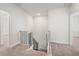 Open loft area with neutral carpet and views of the staircase below at 1246 Allspice Way, Lawrenceville, GA 30045