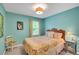 A cozy bedroom with a yellow paisley bedspread, side table with lamp, and a large window at 1384 Independence Way, Marietta, GA 30062