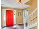 Bright foyer featuring hardwood floors, a red front door, and a view of the staircase at 1384 Independence Way, Marietta, GA 30062
