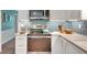 Close-up of a kitchen with white cabinets, stainless steel appliances, and a stylish blue tile backsplash for a modern touch at 1384 Independence Way, Marietta, GA 30062