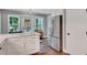 Bright kitchen features white cabinetry, stainless steel refrigerator, and hardwood floors, creating a clean and modern space at 1384 Independence Way, Marietta, GA 30062