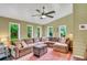Comfortable living room with large sectional couch, ceiling fan and multiple windows with outdoor views at 1384 Independence Way, Marietta, GA 30062