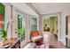 Light-filled sunroom with a wicker chair, hardwood floors, and views to the backyard and connecting living spaces at 1384 Independence Way, Marietta, GA 30062