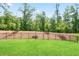 Fenced-in backyard with a spacious green lawn and trees lining the rear boundary at 169 Hickory Bluffs Pkwy, Canton, GA 30114